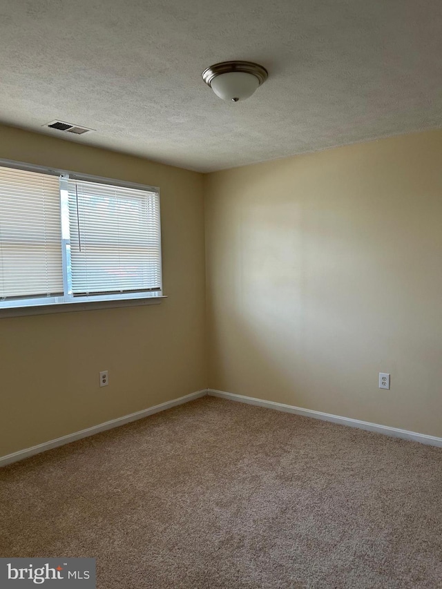 4913 Odell Rd, Beltsville, MD 20705 - unfurnished room featuring visible vents, baseboards, carpet flooring, and a textured ceiling