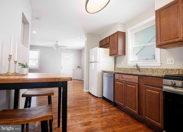 kitchen featuring ceiling fan, electric stove, light stone countertops, dark wood-type flooring, and stainless steel dishwasher