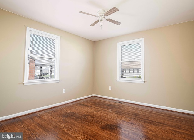 spare room with visible vents, baseboards, ceiling fan, and wood finished floors