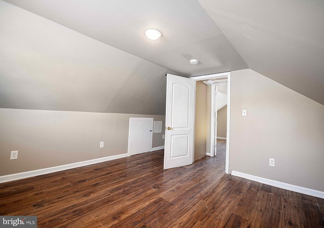 bonus room with dark wood-style flooring, baseboards, and lofted ceiling