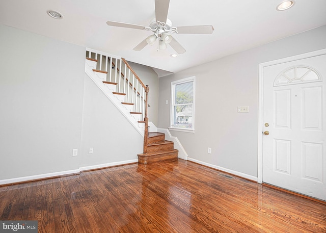 entrance foyer featuring visible vents, baseboards, ceiling fan, stairway, and wood finished floors