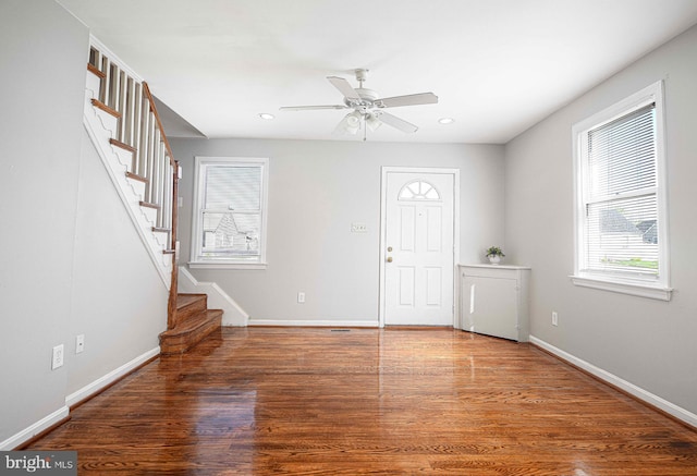 entrance foyer with wood finished floors, ceiling fan, and stairs