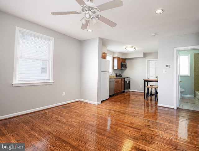 kitchen with a wealth of natural light, wood finished floors, and stainless steel appliances