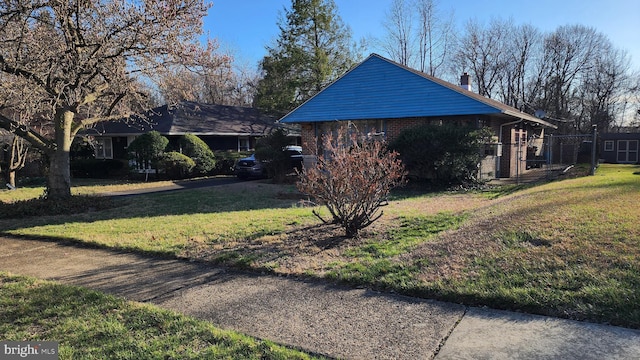 4951 Monument Rd, Philadelphia, PA 19131 - view of property exterior featuring a lawn, brick siding, and a chimney