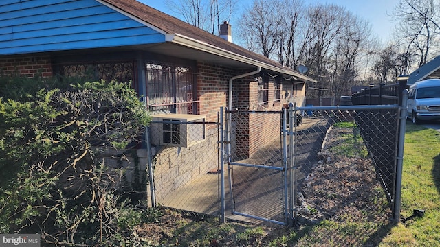 4951 Monument Rd, Philadelphia, PA 19131 - view of side of property with a gate, brick siding, fence, and a chimney