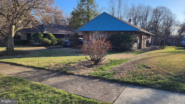 4951 Monument Rd, Philadelphia, PA 19131 - view of side of home featuring brick siding, a yard, and a chimney