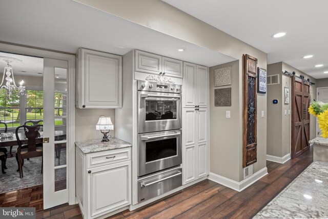 21 Robin Rd, Moorestown, NJ 08057 - kitchen with double oven, a warming drawer, a barn door, a chandelier, and dark wood finished floors