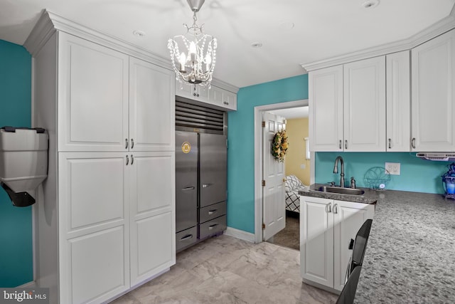 21 Robin Rd, Moorestown, NJ 08057 - kitchen with a sink, white cabinets, stainless steel built in refrigerator, a chandelier, and decorative light fixtures