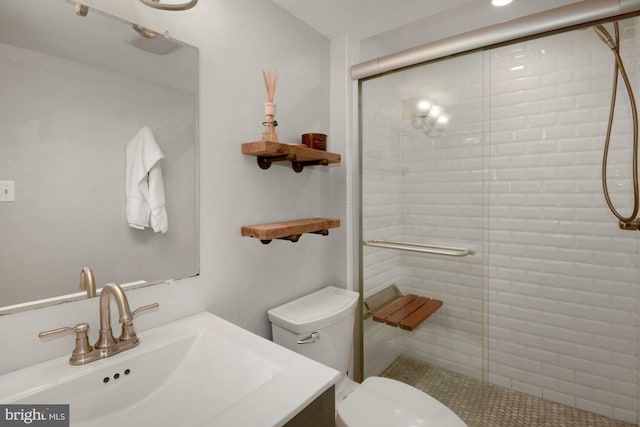full bathroom featuring toilet, a stall shower, and vanity