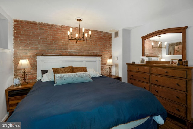 bedroom with an inviting chandelier and brick wall
