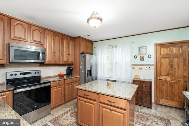 kitchen featuring appliances with stainless steel finishes, light stone counters, and visible vents