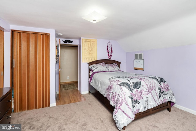 bedroom featuring carpet floors, baseboards, vaulted ceiling, and visible vents