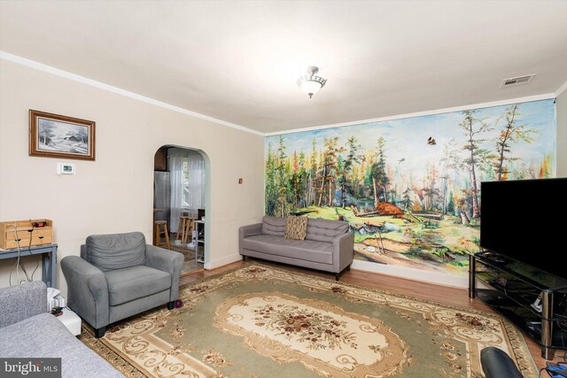 living room with visible vents, baseboards, arched walkways, ornamental molding, and wood finished floors
