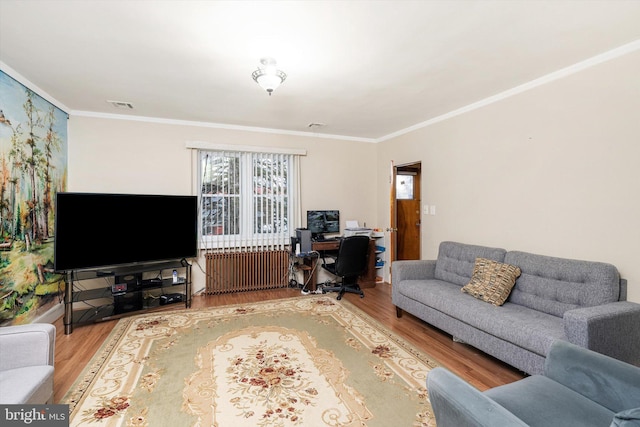 living room featuring crown molding, visible vents, radiator heating unit, and wood finished floors
