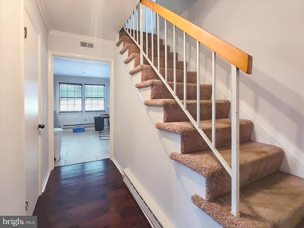 3115 New Coach Ln, Bowie, MD 20716 - staircase with visible vents, a baseboard radiator, ornamental molding, and wood finished floors