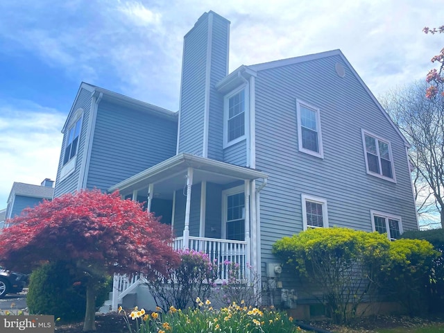97 Kirkwood Dr, Newtown, PA 18940 - view of side of property with a chimney and covered porch
