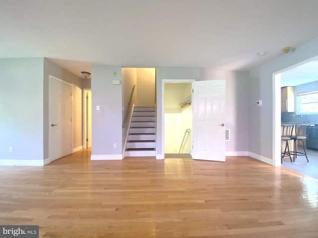 97 Kirkwood Dr, Newtown, PA 18940 - unfurnished living room featuring light wood-style flooring, baseboards, a sink, and stairway