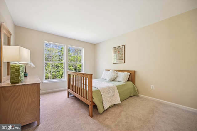 bedroom with baseboards and light carpet