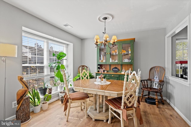 11200 Rienzi Pl Unit 201, Manassas, VA 20109 - dining room with wood-type flooring, baseboards, a notable chandelier, and visible vents