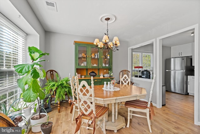 11200 Rienzi Pl Unit 201, Manassas, VA 20109 - dining space with a notable chandelier, visible vents, and light wood finished floors