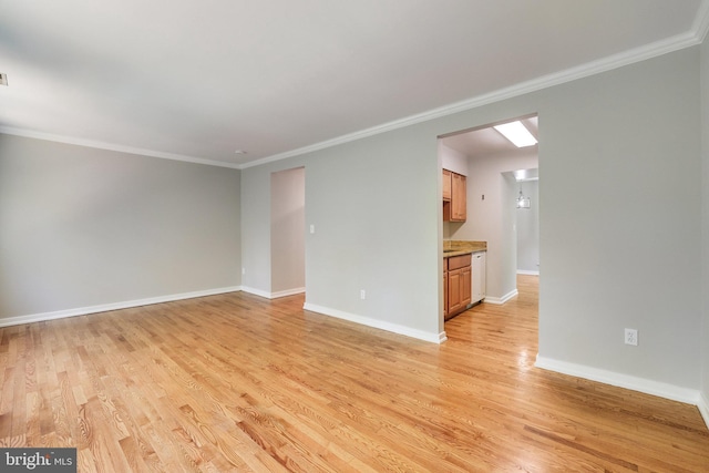 empty room with baseboards, ornamental molding, and light wood-style flooring