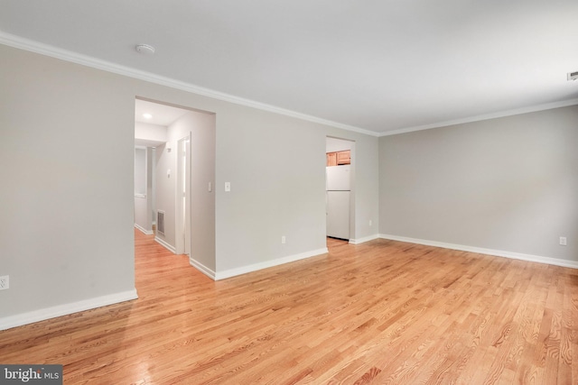 spare room with light wood-type flooring, ornamental molding, and baseboards