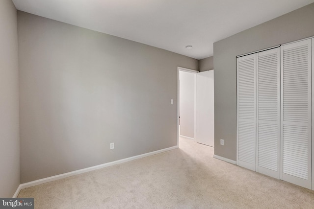unfurnished bedroom featuring carpet floors, baseboards, and a closet