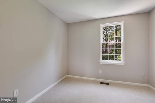 carpeted empty room with visible vents and baseboards