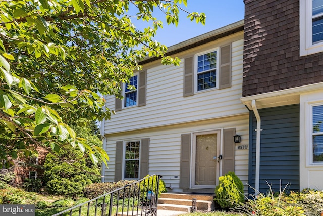 view of front of house featuring fence and a shingled roof