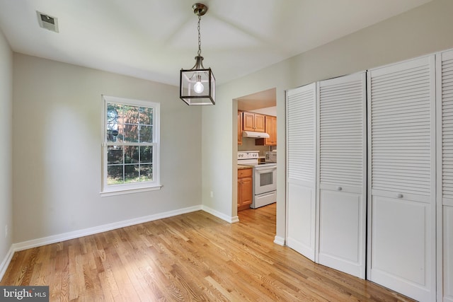 unfurnished dining area with baseboards, light wood-type flooring, and visible vents