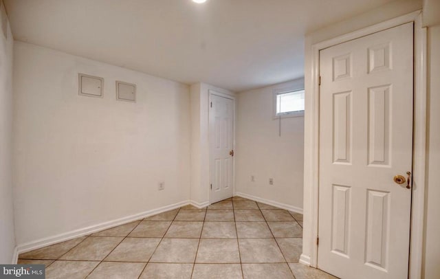 below grade area with baseboards and light tile patterned flooring