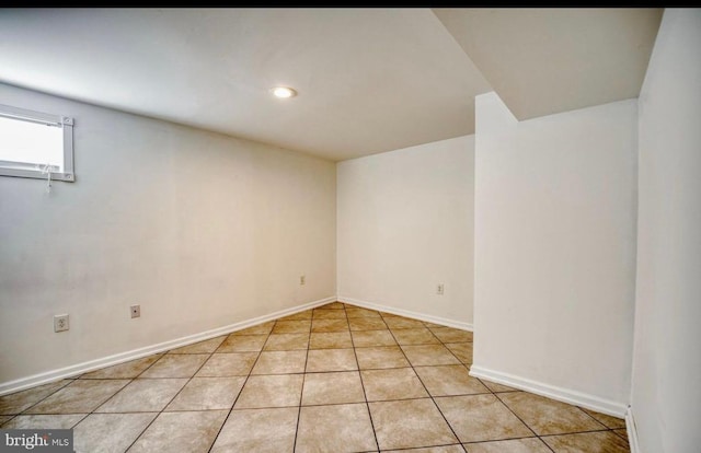 spare room featuring light tile patterned floors and baseboards