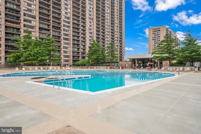 pool featuring fence and a patio