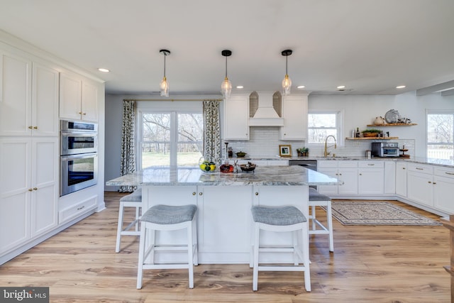 901 Riverside Ave, Grottoes, VA 24441 - kitchen with a kitchen bar, premium range hood, white cabinets, and double oven