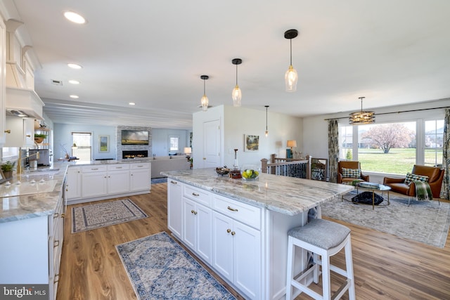 901 Riverside Ave, Grottoes, VA 24441 - kitchen with light stone countertops, light wood-style flooring, white cabinets, recessed lighting, and open floor plan