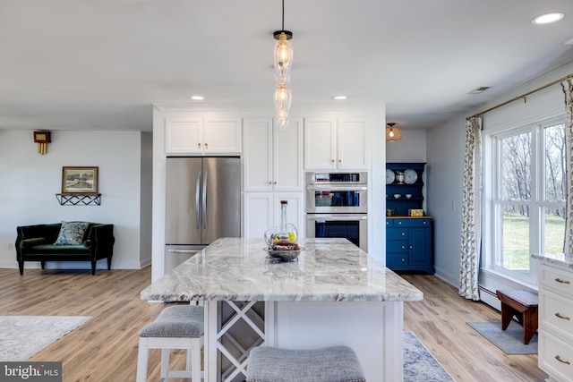 901 Riverside Ave, Grottoes, VA 24441 - kitchen with light stone counters, white cabinets, appliances with stainless steel finishes, light wood finished floors, and a baseboard radiator