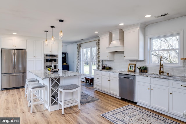 901 Riverside Ave, Grottoes, VA 24441 - kitchen featuring custom exhaust hood, appliances with stainless steel finishes, white cabinetry, decorative backsplash, and a sink