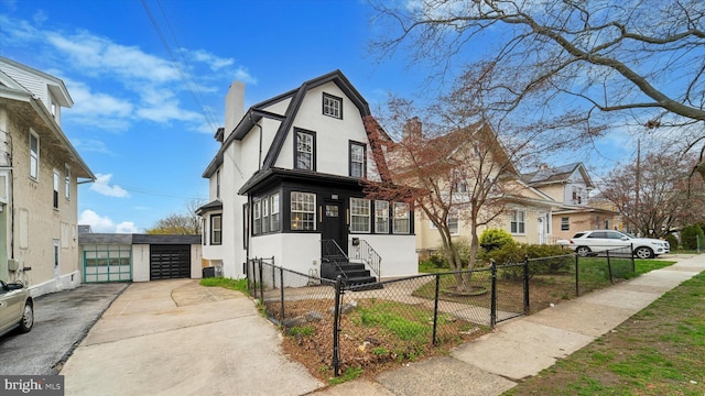 268 Burmont Rd, Drexel Hill, PA 19026 - view of front of home featuring stucco siding, a chimney, a detached garage, and a fenced front yard