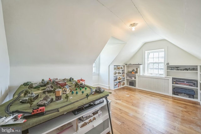 bonus room featuring radiator heating unit, hardwood / wood-style floors, and vaulted ceiling