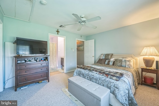 bedroom with visible vents, a ceiling fan, attic access, ensuite bath, and carpet flooring