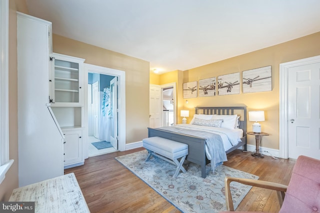 bedroom with baseboards and wood finished floors