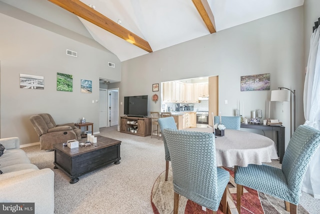 interior space featuring visible vents, high vaulted ceiling, and light carpet