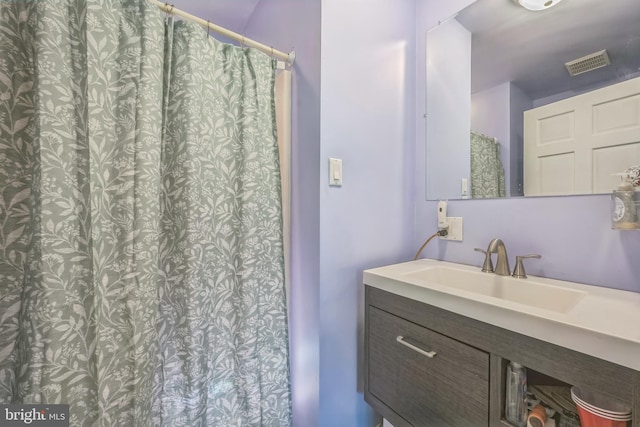 bathroom featuring visible vents, a shower with shower curtain, and vanity