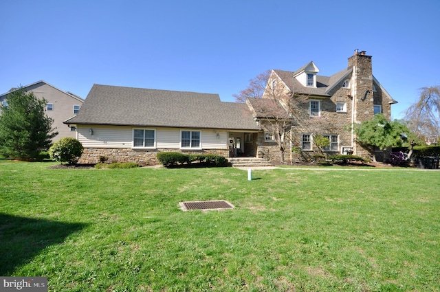 traditional-style home with stone siding, a chimney, and a front lawn
