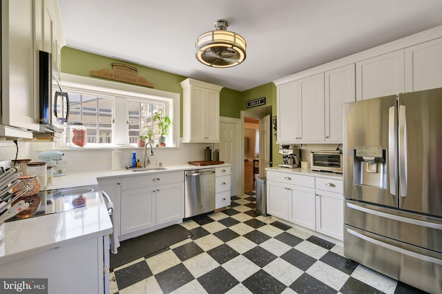 kitchen featuring a sink, light countertops, stainless steel appliances, backsplash, and light floors