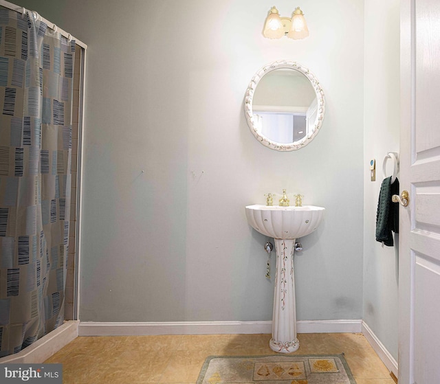 full bath featuring tile patterned floors, a sink, a shower with curtain, baseboards, and a heating unit