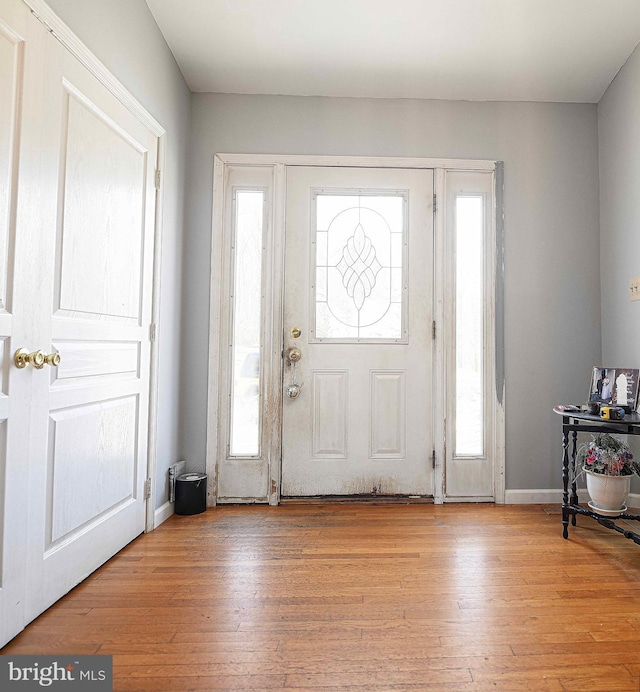 foyer with wood-type flooring and baseboards