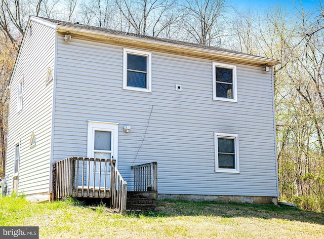rear view of house featuring a lawn