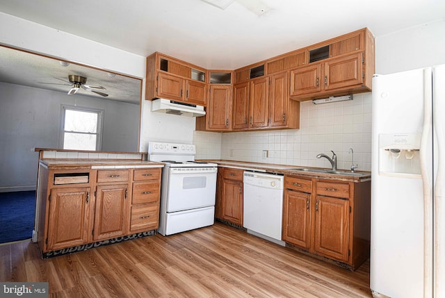 kitchen featuring open shelves, a sink, white appliances, a peninsula, and under cabinet range hood