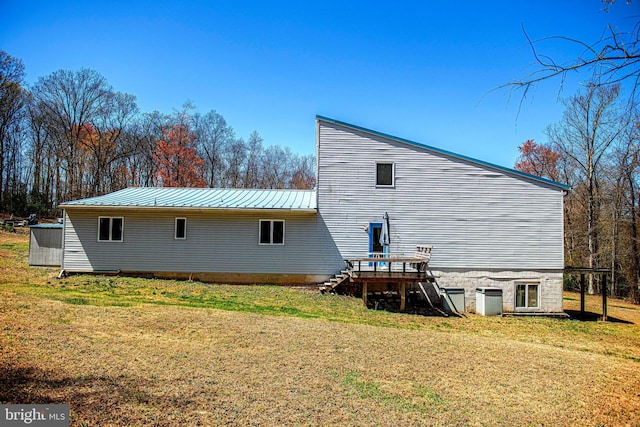 rear view of property featuring a yard, stairs, a deck, and metal roof